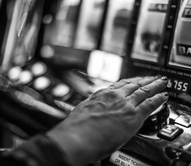 יד של אישה המנסה להגמל מהימורים על מכונה בקזינו 